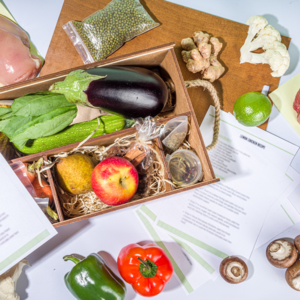 Picture of meal kit box, packaging, recupe card, and ingredients
